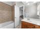 Well-lit bathroom featuring a vanity and a tub/shower combo with neutral tile at 1604 Windy Ridge Rd, Charlotte, NC 28270