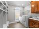 Well-lit laundry room with washer and dryer, built in shelving, and a utility sink at 1604 Windy Ridge Rd, Charlotte, NC 28270