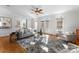 Bright living room featuring neutral colors, a ceiling fan, and multiple windows for ample natural light at 1604 Windy Ridge Rd, Charlotte, NC 28270