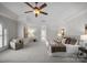 Spacious main bedroom with tray ceiling, ceiling fan, seating area, and a luxurious king bed at 1604 Windy Ridge Rd, Charlotte, NC 28270