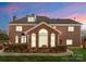 Brick house with well-maintained lawn and landscaping is basked in the evening twilight at 1604 Windy Ridge Rd, Charlotte, NC 28270