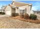 Tan house with brown accents, two-car garage, and landscaping at 1633 Barroso Ln, Charlotte, NC 28213