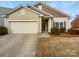 Beige and brown two-story house with a two-car garage and landscaping at 1633 Barroso Ln, Charlotte, NC 28213