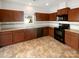 Kitchen with dark wood cabinets, black appliances, and tile flooring at 1633 Barroso Ln, Charlotte, NC 28213