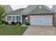 Beautiful single-Gathering home boasting stone accents, a two-car garage, and lush green landscaping at 164 N Cromwell Dr, Mooresville, NC 28115