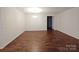 Large, open living space with dark wood floors, neutral paint, and a modern lighting fixture at 164 N Cromwell Dr, Mooresville, NC 28115