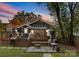 Cozy backyard featuring a wooden deck, a fire pit area, and comfortable bench seating at sunset at 1740 Wilmore Dr, Charlotte, NC 28203