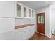 Bright kitchen featuring custom cabinetry with glass fronts and access to the outdoors through a wood door at 1740 Wilmore Dr, Charlotte, NC 28203