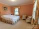 Bright bedroom with floral bedding, two white wicker chairs, and a window with curtains at 2541 Pinewood Rd, Gastonia, NC 28054