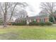 Brick ranch house with mature trees and a well-manicured lawn at 2541 Pinewood Rd, Gastonia, NC 28054