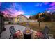 Inviting backyard with string lights, a fire pit surrounded by chairs, and a well-maintained lawn at 27 Dove Sw Ave, Concord, NC 28025