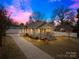 Charming home with a welcoming front porch, long driveway, and beautiful, colorful sunset at 27 Dove Sw Ave, Concord, NC 28025