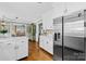 Open-concept kitchen showcases stainless steel refrigerator, white cabinetry, and seamless flow to the living area at 27 Dove Sw Ave, Concord, NC 28025