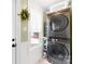 Efficient laundry room with stacked washer and dryer, ample storage shelves, and a bright window at 27 Dove Sw Ave, Concord, NC 28025