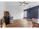 Spacious bonus room featuring wood-look floors, ceiling fan, a window, and blue accent wall at 3028 Summerfield Ridge Ln, Matthews, NC 28105