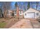 Charming home featuring brick chimney, attached garage, and a welcoming entryway with concrete driveway at 3029 Winding Trl, Matthews, NC 28105