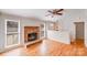 Cozy living room with a brick fireplace, hardwood floors, and a ceiling fan at 3029 Winding Trl, Matthews, NC 28105