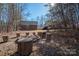 Rustic fire pit surrounded by tree stumps in a wooded backyard at 3044 Old Church Rd, Gastonia, NC 28052