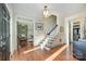 Bright foyer with hardwood floors, staircase with white risers, and elegant light fixture at 3421 Walston Ln, Charlotte, NC 28211