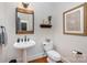 Charming powder room featuring a pedestal sink, decorative mirror, and classic fixtures at 3421 Walston Ln, Charlotte, NC 28211