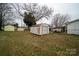 A backyard has multiple sheds, outbuildings, bare trees, and room to garden or play at 504 Glasgow Rd, Charlotte, NC 28214