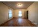 Bedroom with hardwood floors, two windows, and a closet for storage at 504 Glasgow Rd, Charlotte, NC 28214