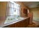 Old kitchen with wood cabinets, a double basin sink, and outdated wallpaper at 504 Glasgow Rd, Charlotte, NC 28214