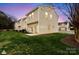 Backyard lawn features a green lawn, patio, and a view of the backs of townhomes at sunset at 528 Fawnborough Ct, Rock Hill, SC 29732