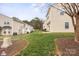 Backyard lawn features a green lawn with a walkway through mulch and a view of the backs of townhomes at 528 Fawnborough Ct, Rock Hill, SC 29732