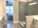 Bright bathroom featuring tile floors, walk-in glass shower with niche, and a view into the bedroom at 553 W Lowrance Ave, Mooresville, NC 28115