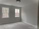 Well-lit bedroom with two windows and neutral carpet at 553 W Lowrance Ave, Mooresville, NC 28115