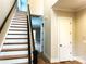 Bright foyer with staircase featuring wood treads, white risers, and dark wood railing at 553 W Lowrance Ave, Mooresville, NC 28115