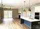 Open kitchen with island, white cabinets, and gold pendant lights at 553 W Lowrance Ave, Mooresville, NC 28115