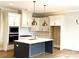 Modern kitchen with white cabinets, blue island, and gold pendant lighting at 553 W Lowrance Ave, Mooresville, NC 28115