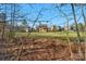 View of a large backyard surrounded by mature trees, offering privacy and space at 7219 Yellowhorn Trl, Waxhaw, NC 28173