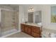 Bathroom features a glass-enclosed shower, double vanity with wood cabinets and a large mirror, offering modern luxury at 7219 Yellowhorn Trl, Waxhaw, NC 28173