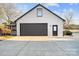 Detached garage with dark brown double doors and white brick exterior at 8478 Rocky River Rd, Harrisburg, NC 28075