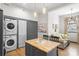 Modern kitchen with gray cabinets, butcher block island, and laundry closet at 8478 Rocky River Rd, Harrisburg, NC 28075