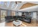 Sunroom with vaulted ceiling, skylights, a large sectional sofa, and a fireplace at 8478 Rocky River Rd, Harrisburg, NC 28075