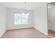 Dining room featuring wood flooring and a modern chandelier with a large window at 8714 Summer Serenade Dr, Huntersville, NC 28078