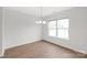 Bright dining area with wood floors, a chandelier, and a large window at 8714 Summer Serenade Dr, Huntersville, NC 28078