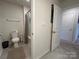 View of the toilet and shower area with a shower curtain and a built in towel rack at 104 Sycamore Crossing Ct, Locust, NC 28097