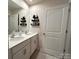 Bathroom featuring a double sink vanity, wall shelves, and a large mirror at 104 Sycamore Crossing Ct, Locust, NC 28097