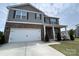 Inviting two-story home featuring a stone facade and a well-maintained lawn with garden at 104 Sycamore Crossing Ct, Locust, NC 28097