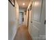 Hallway with neutral carpeting, multiple doors, and neutral paint at 104 Sycamore Crossing Ct, Locust, NC 28097