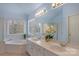 Bright bathroom featuring a dual sink vanity, garden tub, and a window providing ample natural light at 10417 Sutherby Dr, Charlotte, NC 28277