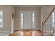 Bright foyer features hardwood floors, staircase, and neutral paint offering a clean, inviting ambiance at 10417 Sutherby Dr, Charlotte, NC 28277