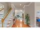 Bright foyer featuring hardwood floors, staircase, and decorative plants that enhance a welcoming atmosphere at 10417 Sutherby Dr, Charlotte, NC 28277