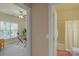 Hallway view showing an office with large window and ceiling fan, and the entrance to the bathroom at 10417 Sutherby Dr, Charlotte, NC 28277