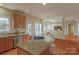 Spacious kitchen featuring a large island with a cooktop, granite countertops, and wooden cabinets at 10417 Sutherby Dr, Charlotte, NC 28277